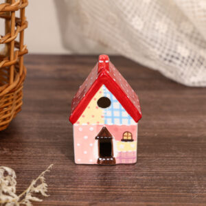 Hand-painted red roof ceramic house ornament with pink walls and blue patchwork details