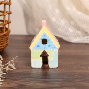Hand-painted pastel ceramic house ornament with blue star details and yellow roof