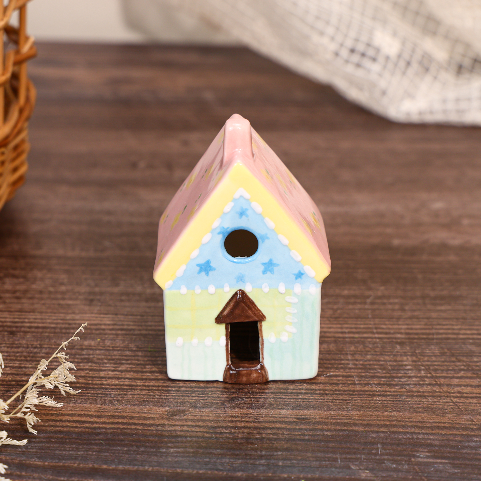 Hand-painted pastel ceramic house ornament with blue star details and yellow roof