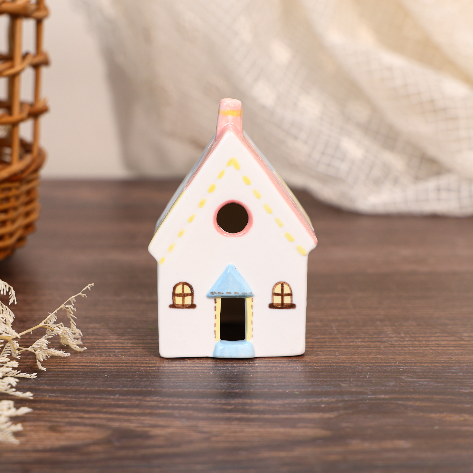 Hand-painted pastel cottage ceramic house ornament with pink walls and blue door detail
