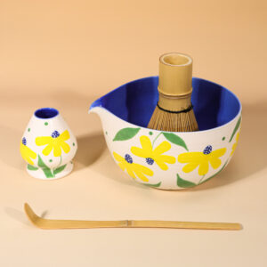 Hand-painted yellow daisy ceramic matcha set with blue bowl interior and bamboo tools