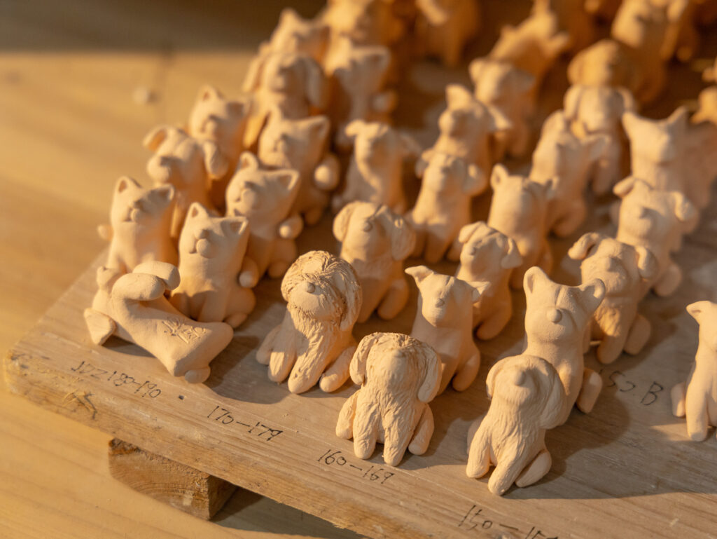 Unglazed handmade animal figurines arranged for a small batch