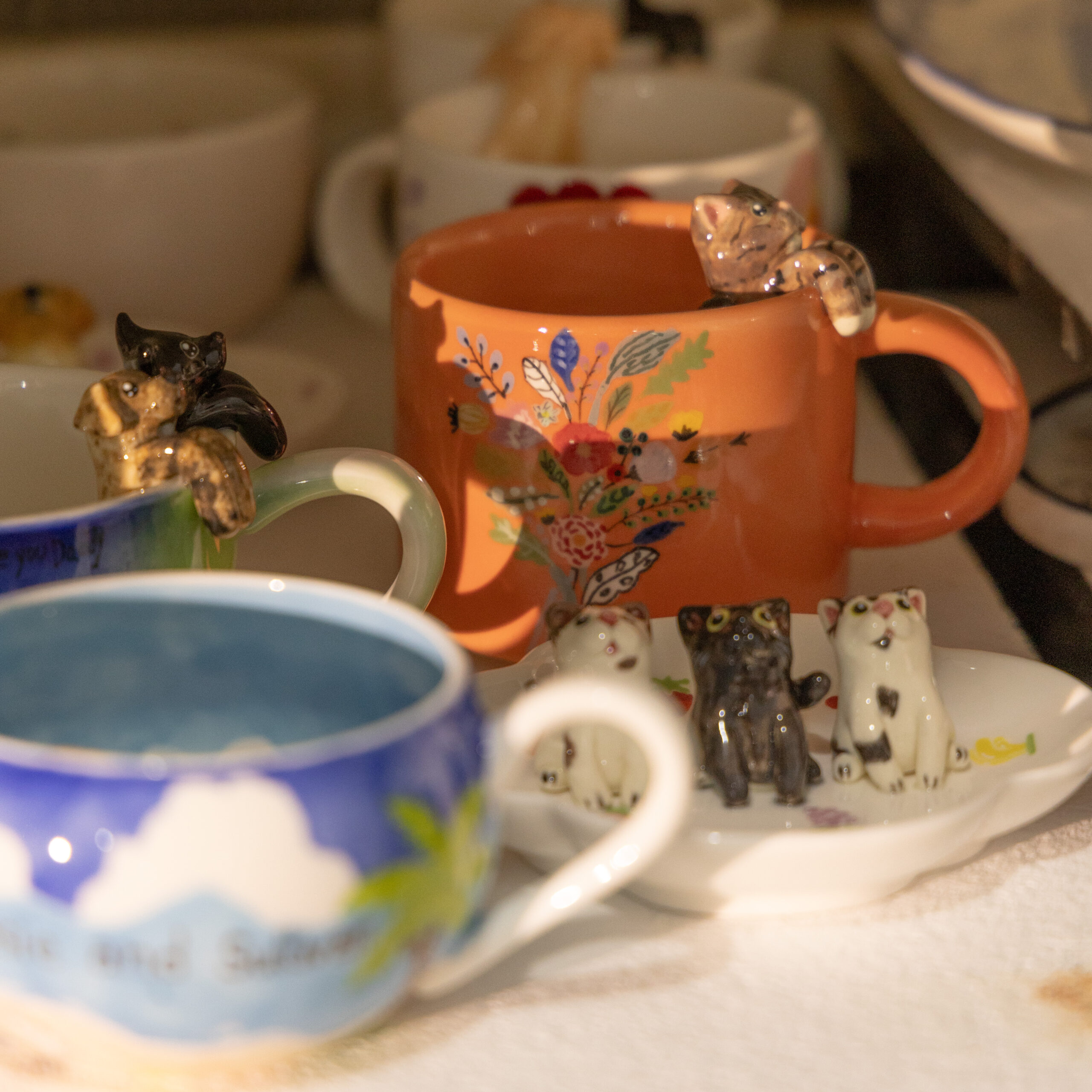 Hand-painted custom porcelain cup with small animal figurines in the studio